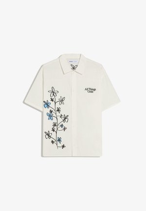 Chemise blanche à manches courtes avec boutons, motif floral noir et bleu sur le côté gauche et texte « All Things Gone » sur le côté droit de la poitrine.