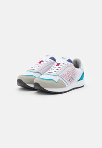 Sneakers bianchi con accenti blu, rossi e grigi. Presentano materiali in rete e suede, punta rotonda e logo laterale a motivo. Suola in gomma piatta.