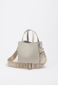 Bolso de cuero beige con dos asas en la parte superior y una correa de lona desmontable que presenta el lema "BIMBA Y LOLA". Diseño elegante y minimalista.