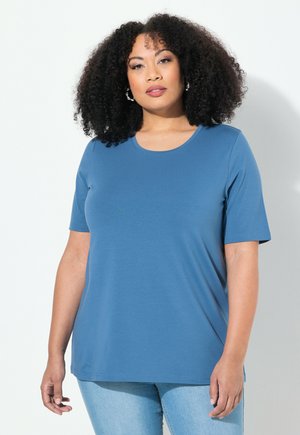 Blauwe, korte mouwen t-shirt met een ronde hals, gemaakt van zachte stof. Heeft een relaxte pasvorm. Wordt gedragen met lichtgewassen jeans.