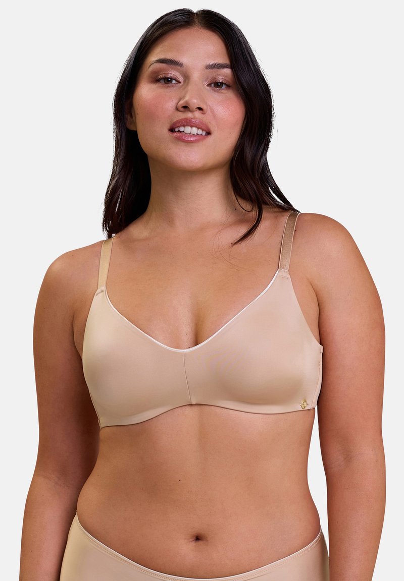 Soutien-gorge sans fil nude en tissu lisse, design en V, bretelles réglables et un petit logo décoratif sur le côté gauche.