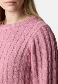Rosa gestrickter Pullover mit einem strukturierten Kabelmuster, rundem Ausschnitt und gerippten Bündchen, der weichen, gewebten Stoff hervorhebt.