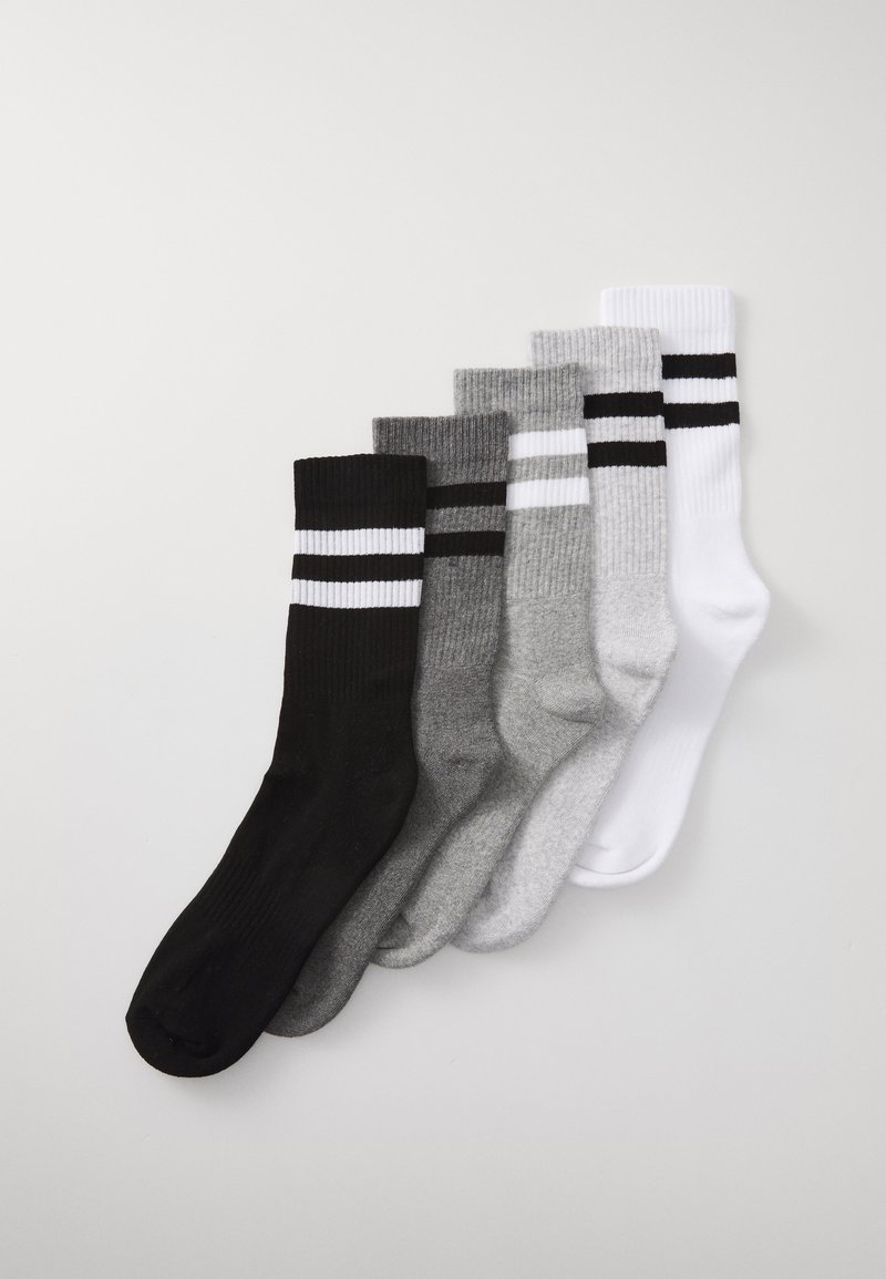 Fünf Paar Crew-Socken in Schwarz, Grau und Weiß. Mit geripptem Textur und zwei horizontalen Streifen nahe der Oberkante jeder Socke.