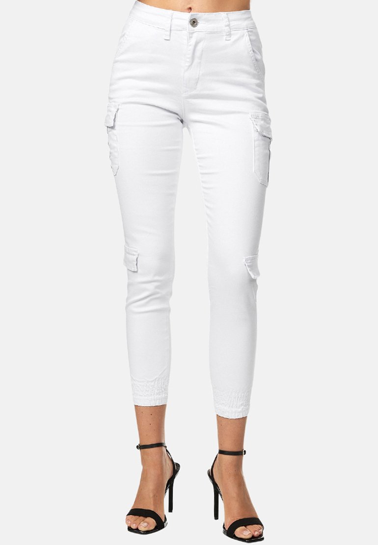 Witte cargo broek met een slim fit, voorzien van zijzakken, lichte slijtage, rekbare enkelboorden, gecombineerd met zwarte hakken met bandjes.