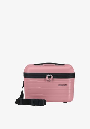 Valigia rigida rosa con design scanalato, chiusura a doppia cerniera, dettagli neri e tracolla regolabile. Forma compatta e rettangolare.