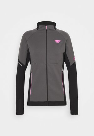 Veste de sport grise avec des manches noires et des accents roses. Elle présente un col montant, une fermeture éclair complète et des poches latérales zippées. Texture lisse.