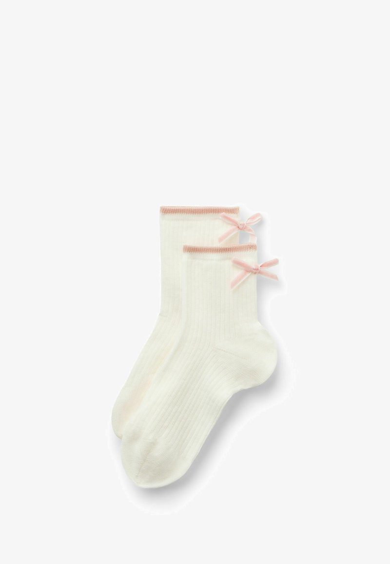 Calze bianche a coste con dettagli rosa e piccoli fiocchi sui lati. Realizzate in un materiale morbido, presentano un design alla caviglia confortevole.