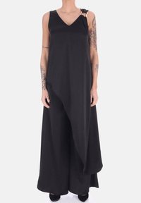 Abito nero senza maniche con scollatura a V, orlo asimmetrico, un solo dettaglio d'accento sulla spalla e una texture morbida e fluida.