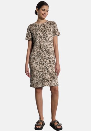 Abito t-shirt a stampa leopardata in tonalità beige e nero, con una vestibilità comoda, maniche corte e orlo lungo fino al ginocchio. Indossato con sandali neri a scivolo.