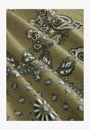 Green fabric featuring a paisley pattern in navy and white. Textured surface with intricate details and varying designs.