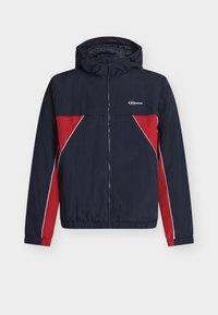 Μπλε ναυτικό και κόκκινο αδιάβροχο με φερμουάρ μπροστά, κουκούλα, ελαστικά τελειώματα στα μανίκια και στρίφωμα. Διαθέτει διαγώνιες κόκκινες λεπτομέρειες και λευκές ρίγες.