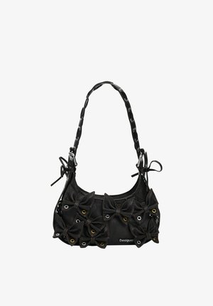 Sort læderhåndtaske med en rund form, der har flere sløjfeapplikationer, metaløjer og en flettet rem. Mærkenavn synligt.