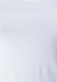 T-shirt de algodão branco com uma textura suave e lisa. Apresenta um decote redondo e um design sem costuras, adequado para sobreposições ou uso casual.