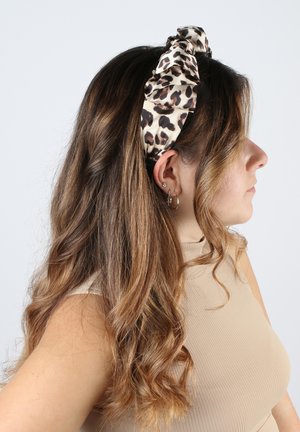 Stirnband mit Leopardenmuster aus Satin, mit einem verknoteten Design an der Vorderseite und einer glatten Textur.