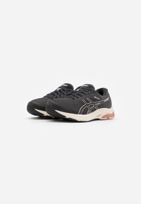 Par de zapatillas de correr Asics en negro y rosa con suelas blancas y amortiguación transparente, mostradas en ángulo sobre fondo blanco.