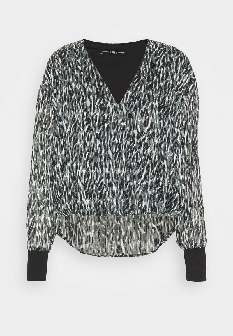 Blusa de estampado en blanco y negro con escote en V, mangas largas, cinturilla elástica y una tela fluida y transparente.