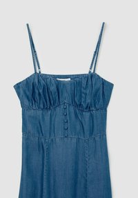Robe en denim avec des bretelles fines et réglables, corsage froncé et un détail de cinq boutons sur le devant. Tissu doux et texturé, couleur bleu foncé.