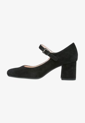 Schwarze Wildleder-Mary-Jane-Schuhe mit runder Spitze, einem Schnallenriemen über dem Rist und einem quadratischen Blockabsatz. Glatte Textur, minimales Design.