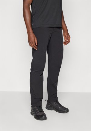 Men's black outdoor pants made from lightweight, stretchy fabric; features tapered design, multiple seams, and reinforced knee panels.