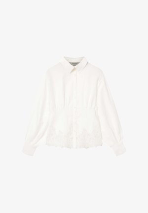 Biała koszula na guziki z klasycznym kołnierzem, plisowaną fakturą w talii i misternymi koronkowymi zdobieniami na dole. Długie rękawy z mankietami.