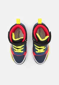 Sneakers blu con dettagli rossi, cinturini neri, lacci gialli e una suola bianca. Materiale testurizzato con colletto imbottito per il comfort.