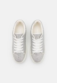 Scarpe da ginnastica argento coperte di strass, con lacci bianchi, punta tonda e un design testurizzato sulla parte superiore. Suola in gomma bianca.
