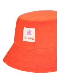Cappello a secchiello arancione in tessuto morbido, con un bordo cucito e un'etichetta bianca con un logo a sole e il testo "BILLABONG".