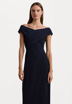 Navy off-the-shoulder dress with a fitted bodice, pleated detailing, and a flowy skirt. Made from a smooth, textured fabric.