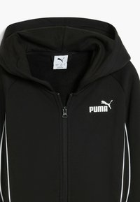 Felpa nera con zip, caratterizzata da un logo Puma bianco sul petto e da strisce bianche a contrasto lungo i lati. L'interno è foderato in pile.