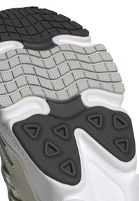 Podeszwa buta ma czarną i szaro-rubinową gumową bieżnię z teksturowanym wzorem. Projekt zawiera akcenty w kszta łcie trójkątów oraz białe wykończenia boczne.