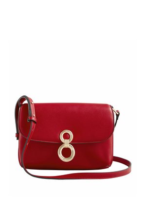 Bolso bandolera de cuero rojo con cierre circular dorado y correa de hombro ajustable sobre fondo blanco.