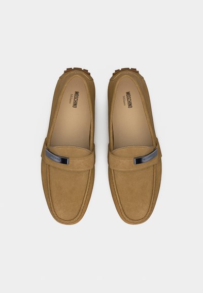 Paire de mocassins en daim marron clair avec un bout carré arrondi et un détail en barre métallique sur le dessus, marque Moschino Milano à l'intérieur.