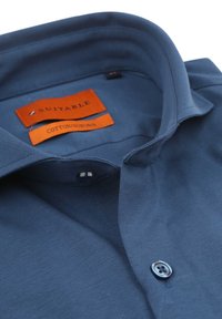 Donkerblauwe, kortebloemige katoenen blended shirt met een puntige kraag, voorzien van een oranje label en een enkele knoopdetail bij de kraag.