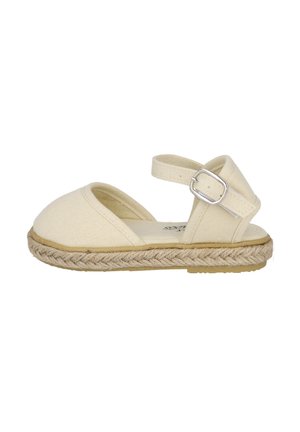 Sandalia espadrille de lona beige con puntera cerrada, tira en el tobillo, hebilla plateada y suela trenzada de yute sobre base de goma plana.