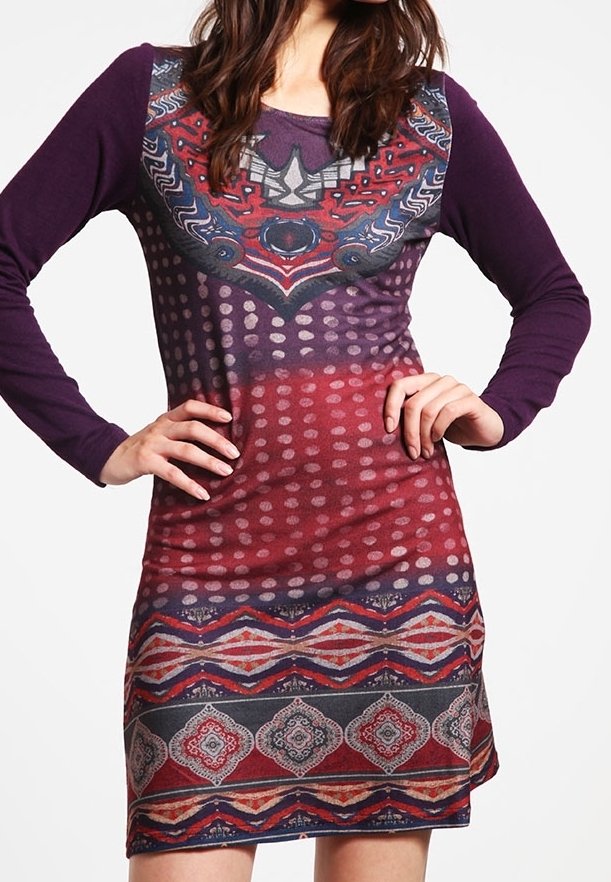 Langemouwen jurk in paars en rood, met een gebloemde corsage met geometrische vormen, stippen en een decoratieve zoom.