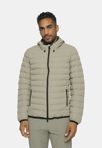 Gepolsterte, hellbeige Jacke mit Kapuze, mit einem Reißverschluss, elastischen Bündchen und schwarzen Akzenten. Das Material wirkt glatt und weich.