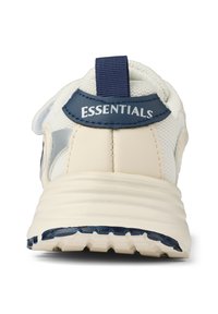 Beige athletic shoe features a textured upper with mesh and a navy accent. The back has a pull tab and "ESSENTIALS" stitched in white.