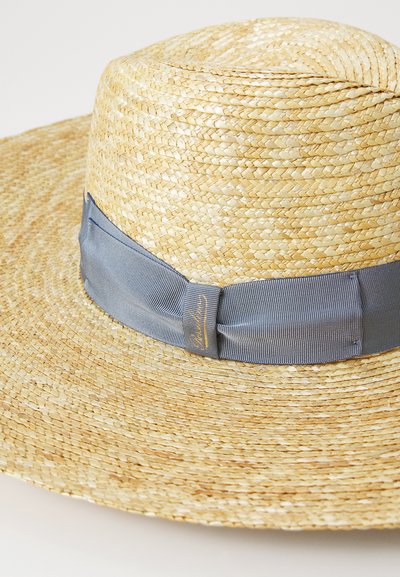 Pălărie din paie cu boruri largi, în nuanțe naturale, având o bandă din satin blue netedă. Paie texturată cu un model împletit.
