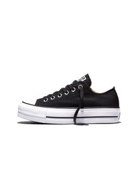 Nizki črni platneni supergi z belim gumijastim podplatom, črto na čevlju, kovinskimi luknjicami in ohlapnim črnim vezalkam na belem ozadju.