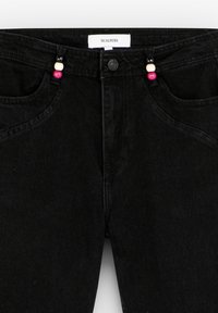 Black denim jeans with a textured finish. Features colorful bead accents on the front pocket, with a standard button and zipper closure.