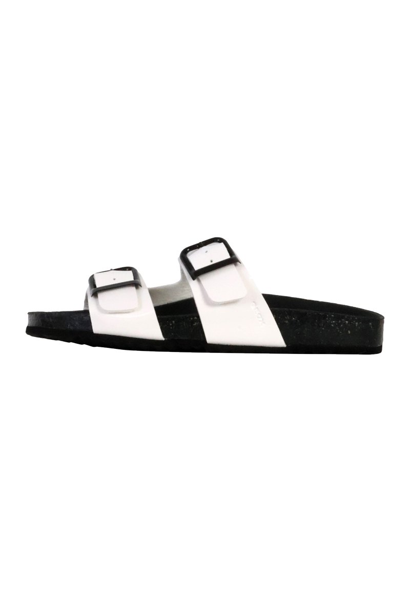 Sandal in bianco e nero con due cinturini e fibbie regolabili, in materiale testurizzato, e una suola nera spessa, progettata per comfort e stabilità.