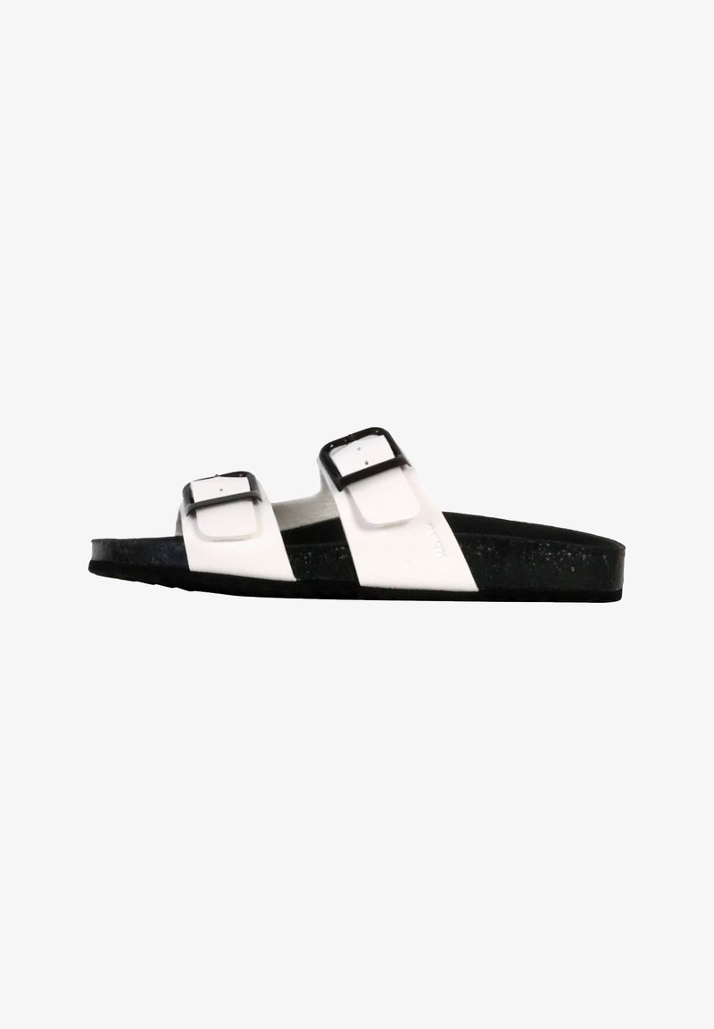 Sandal in bianco e nero con due cinturini e fibbie regolabili, in materiale testurizzato, e una suola nera spessa, progettata per comfort e stabilità.