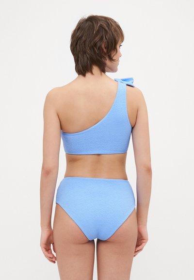 Modrý bikiny top s jedním ramínkem a detailem mašle, doplněný o vysoké kalhotky. Texturovaná tkanina, jednobarevná, hladký povrch.