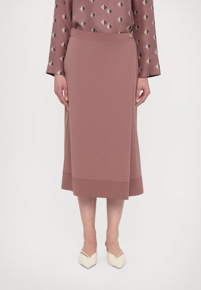 Jupe crayon mauve avec une texture lisse, longueur genou, dotée d'une ceinture propre et de subtils accents d'ourlet. Porte des ballerines pointues de couleur claire.