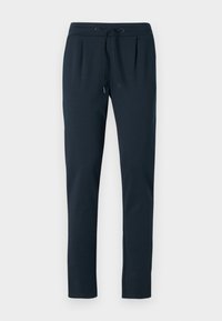 Mörkblå mjukisbyxor i mjukt tyg, med dragsko i midjan, avsmalnande ben och sidofickor. Slät textur, minimal design.