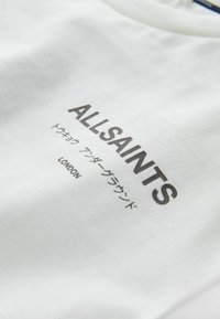 White cotton t-shirt featuring the text "ALLSAINTS" and "LONDON" in dark gray, with additional Japanese characters underneath. Smooth texture.