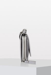 Šedá kožená peněženka se zipovým uzávěrem, štíhlý profil a boční smyčka pro připevnění. Disponuje hladkým povrchem a jednoduchým designem.