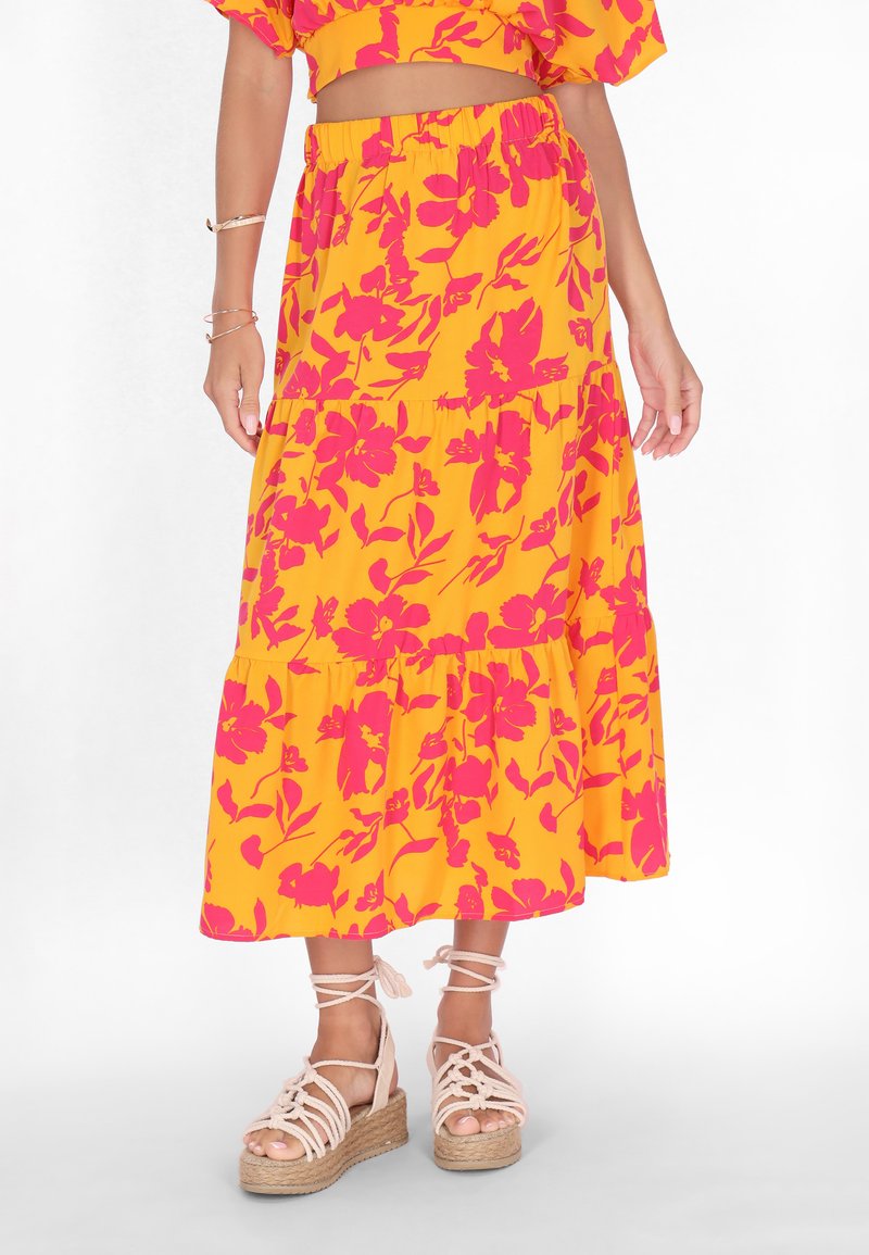 Gul blomster maxi skørter med pink blomster mønstre, lagdelte flæser og elastisk talje, parret med lyserøde espadrille sandaler.