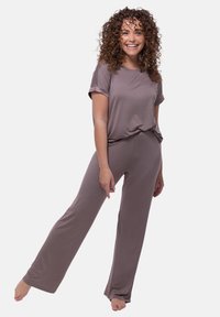 Tvådelad lounge-set i dämpad brun, med en avslappnad kortärmad topp och raka byxor, tillverkade av mjukt tyg.