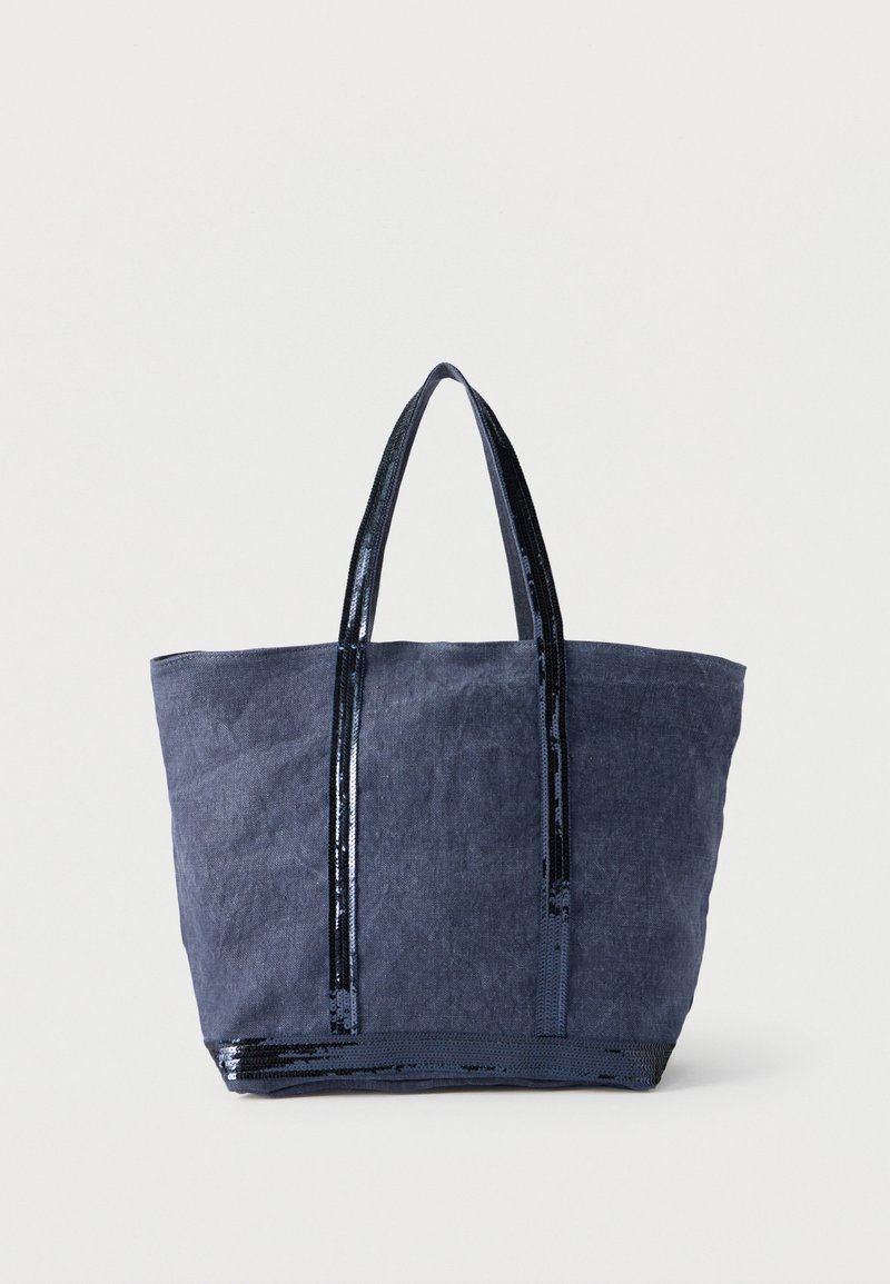Sac cabas bleu marine en tissu, avec des accents en sequins noirs brillants et deux poignées robustes. Le design est spacieux et rectangulaire.